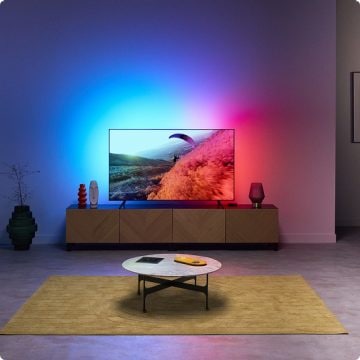 A living room with immersive light coming from the TV Backlight, synced to the colors of the TV screen.