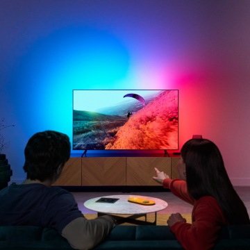 Un couple profite de la lumière LED pour la télévision avec des couleurs synchronisées avec l'écran.